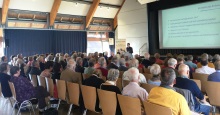 Auditorium bei einem VOrtrag in einer Halle von hinten