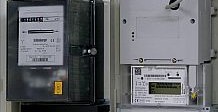 Analoger Ferraris-Stromzähler neben einem digitalen Stromzähler / Smart Meter