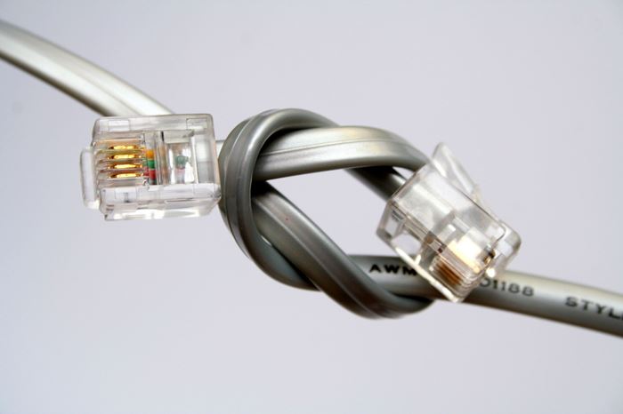 Nahaufnahme zweier grauer verknoteter Netzwerkkabel Nahaufnahme zweier grauer verknoteter Netzwerkkabel