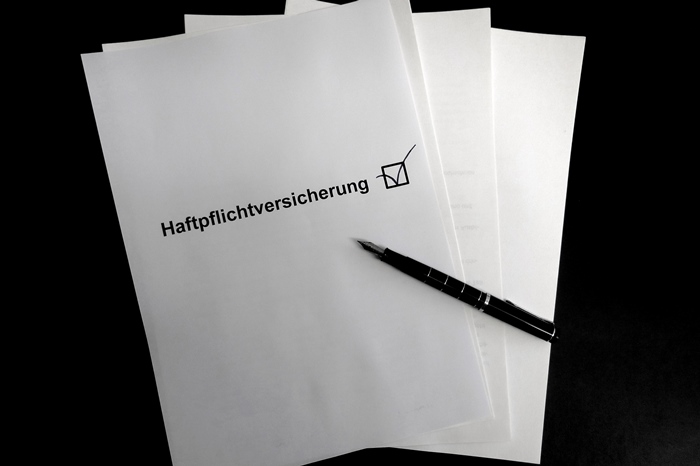 4 DIN-A4-Blätter mit schwarzem Kuli auf schwarzem Grund, das oberste mit der Aufschrift